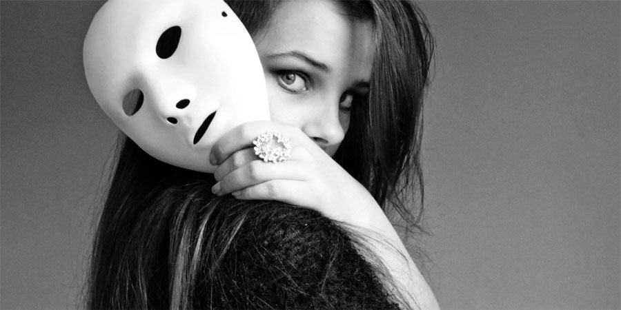 Ragazza con maschera bianca in mano